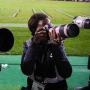 students using long lens cameras on the sideline of a Buffs football game
