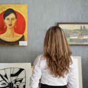A woman looking at paintings