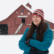 Rebecca Safran standing outside in the snow in front of a barn